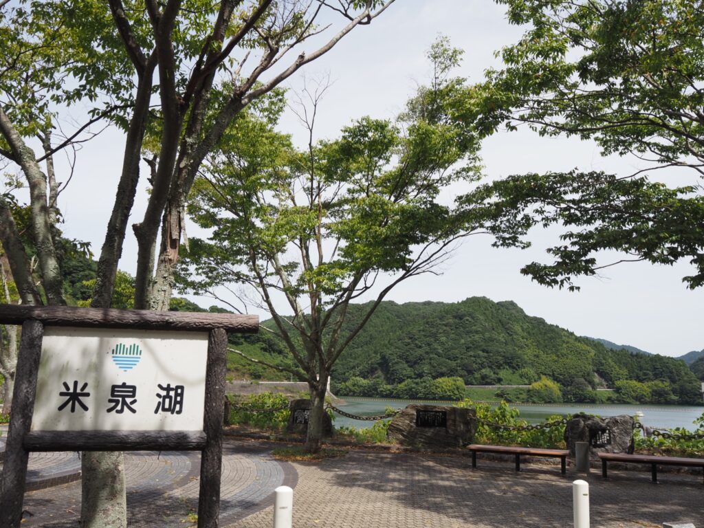 米泉湖の看板と湖を囲む山々